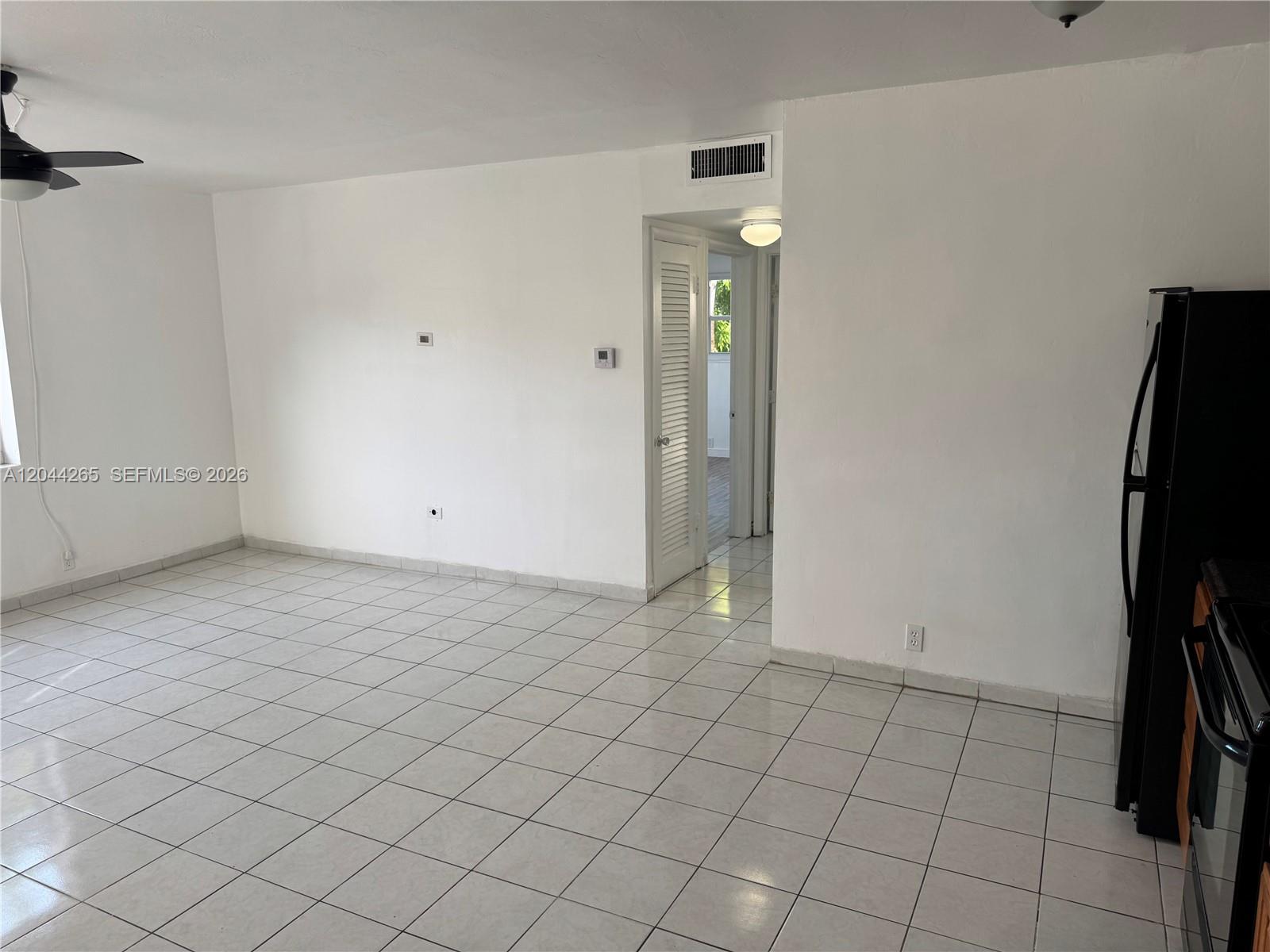 A white-walled room features light-colored floor tiles, a ceiling fan, and a doorway — 1765 Venice Ln # 4E, North Miami FL 33181, NORTH MIAMI, FL