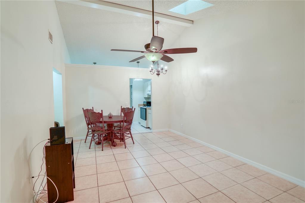 A dining area with tile flooring, a ceiling fan, and a view into the kitchen — 407 DOUGLAS WAY UNIT 66, WINTER GARDEN, FL