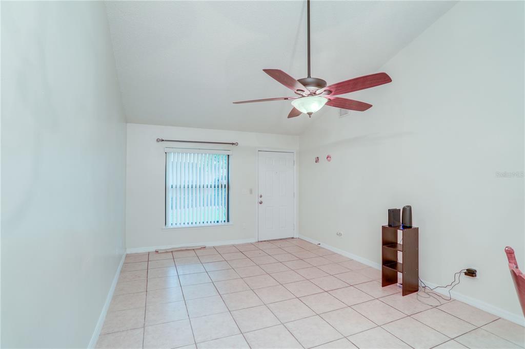 A room with light-colored tile flooring, a ceiling fan, a window with blinds, and a door — 407 DOUGLAS WAY UNIT 66, WINTER GARDEN, FL