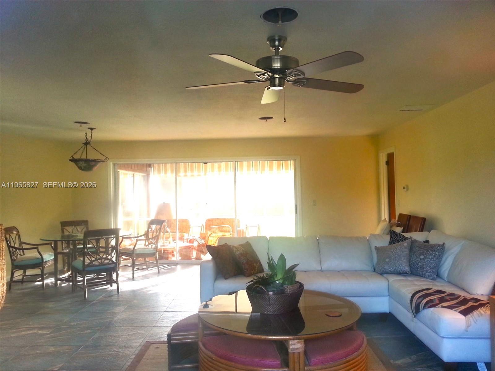 A living room features a white sectional sofa, a glass coffee table, and a dining area — OTHER CITY - IN THE STATE OF FLORIDA, FL