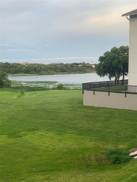 A view of a grassy lawn leading to a lake with a building balcony nearby — 1064 LOTUS PARKWAY UNIT 915, ALTAMONTE SPRINGS, FL