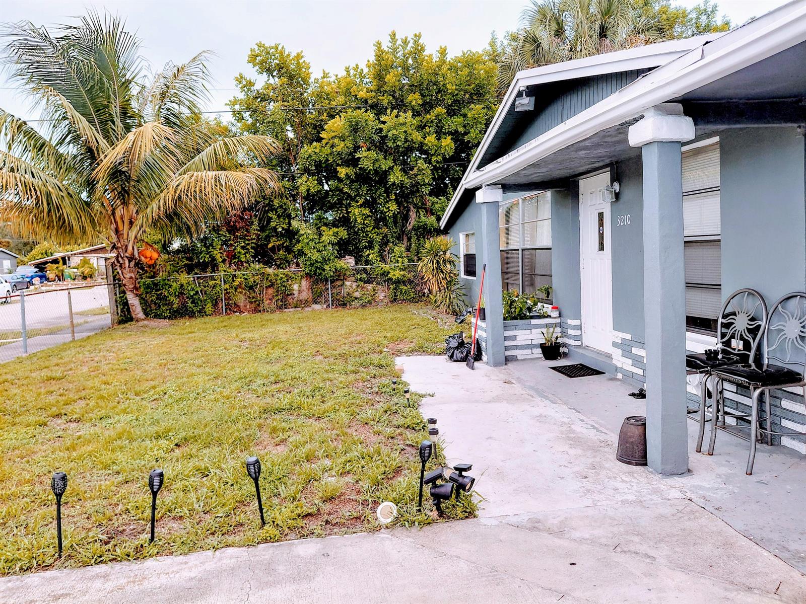 A gray house with a front porch, a small lawn, and a palm tree — 3210 NW 18th Place, Lauderhill FL 33311, LAUDERHILL, FL