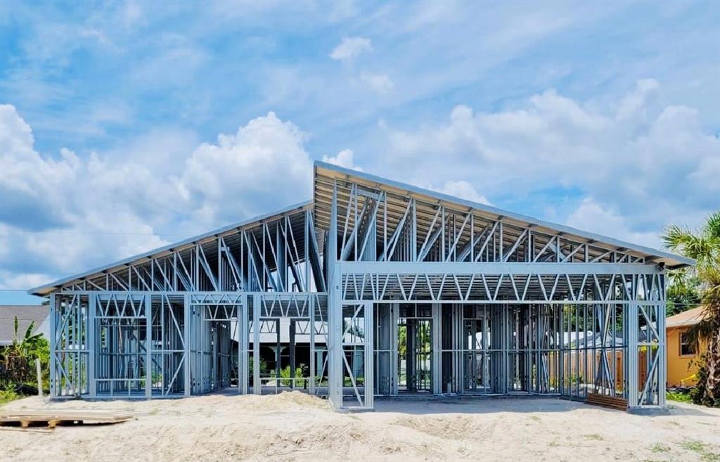A new house under construction featuring a metal frame structure against a blue sky — 27367 CHINQUAPIN DRIVE, PUNTA GORDA, FL