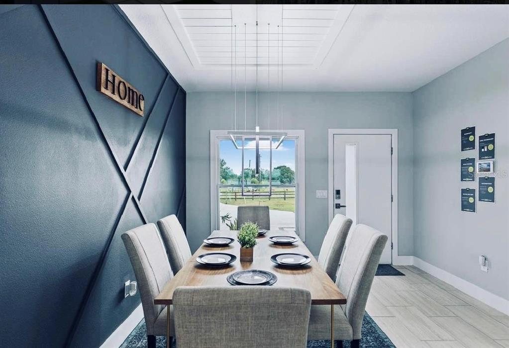 A dining room features a dark blue accent wall with geometric trim and a wooden table — 27367 CHINQUAPIN DRIVE, PUNTA GORDA, FL