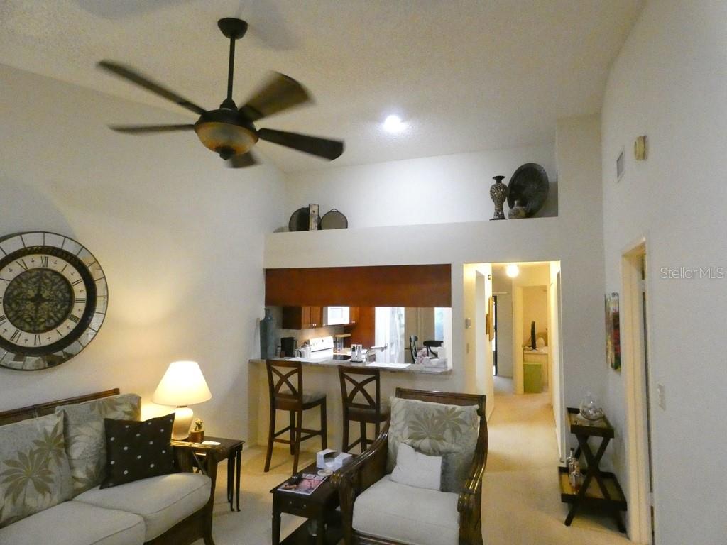 A living room with a ceiling fan, a breakfast bar, and a lofted display area — 2749 COUNTRYSIDE BOULEVARD UNIT 28, CLEARWATER, FL