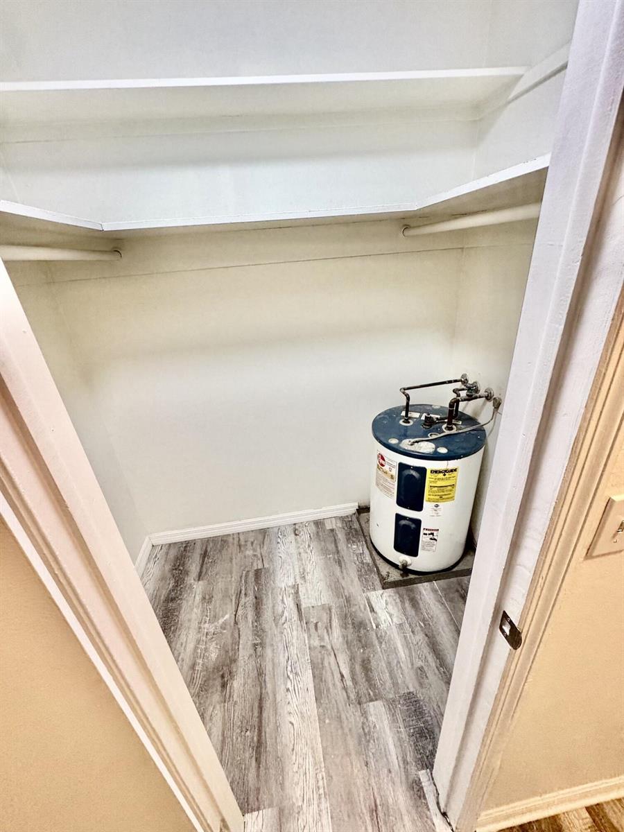 A closet with wood-look flooring, white shelving, and an electric water heater — 417 N K Street # 1a, FL 33460, FL