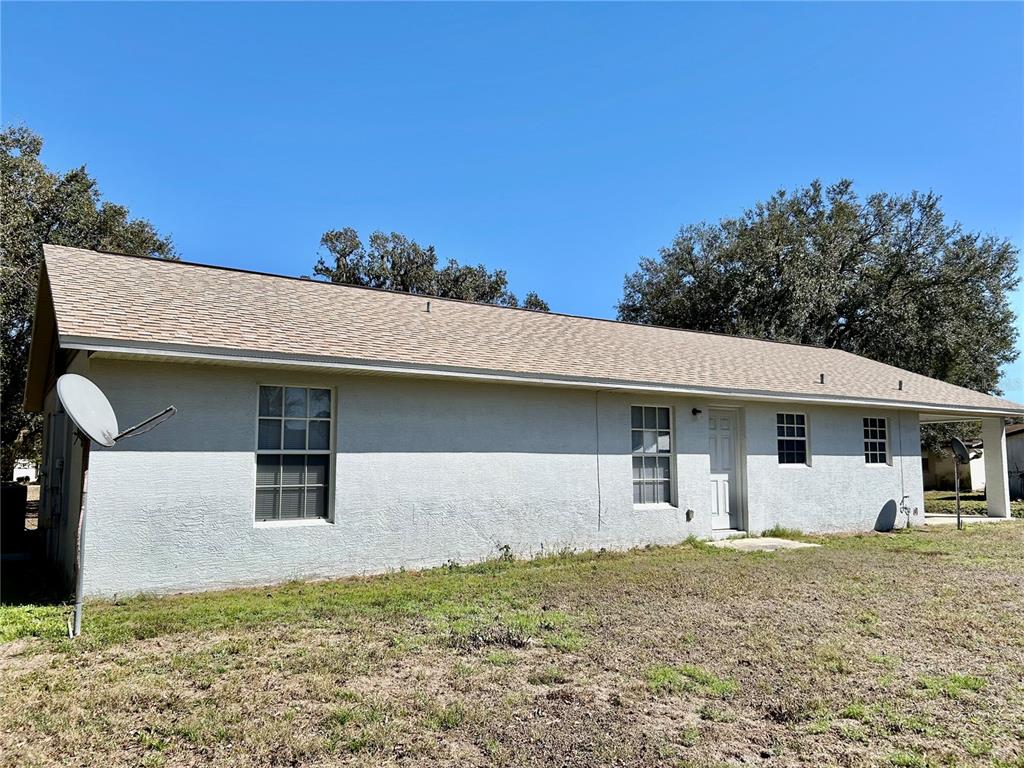 The exterior of a single-story house with a light-colored stucco finish and a shingled roof — 3456 ELM STREET, ZOLFO SPRINGS, FL