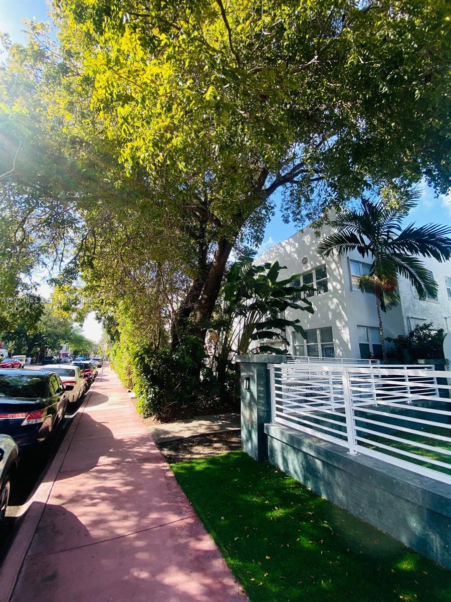 A sidewalk runs alongside a street with parked cars and a multi-story building — 1550 Drexel Ave # 202, Miami Beach FL 33139, MIAMI BEACH, FL
