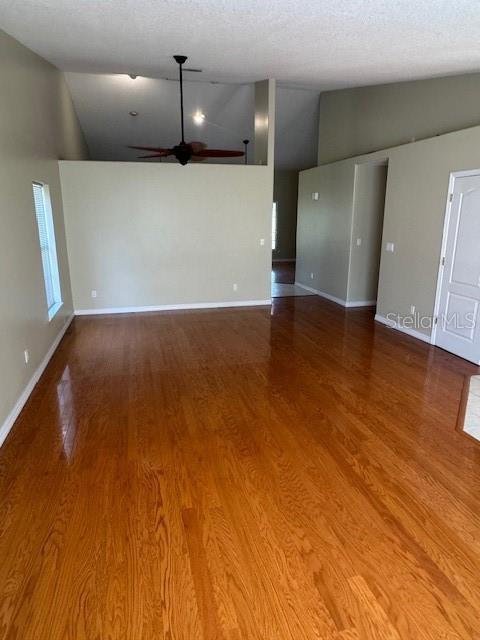 An empty room features hardwood flooring, light-colored walls, and a ceiling fan — 6741 NORTHLAKE DRIVE, ZEPHYRHILLS, FL