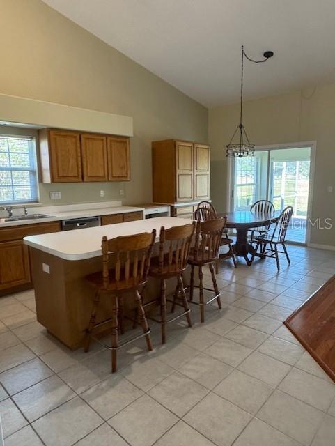 A kitchen features light wood cabinets, a central island with bar stools, and a dining area — 6741 NORTHLAKE DRIVE, ZEPHYRHILLS, FL