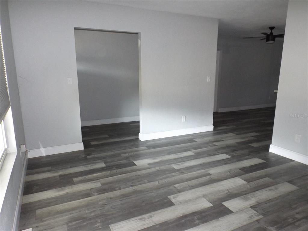 An interior room features gray walls, white baseboards, and wood-look plank flooring — 199 8TH STREET SE, WINTER HAVEN, FL