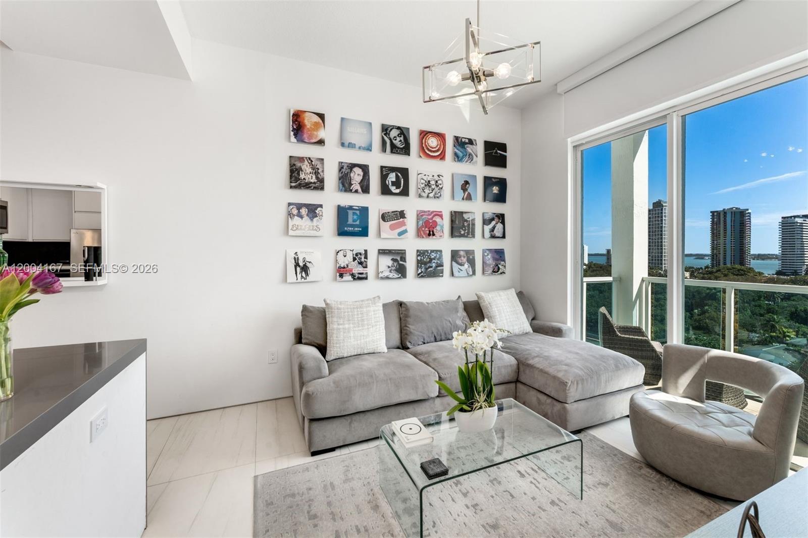 A living room features a gray sectional sofa, a glass coffee table, and a wall display — 1723 SW 2nd Ave, Miami FL 33129, MIAMI, FL