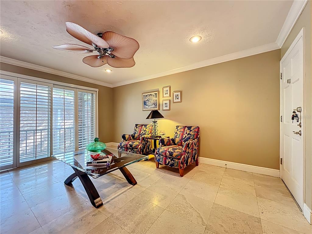 A living room features tile flooring, a palm-leaf ceiling fan, and two patterned armchairs — 4212 LAKE UNDERHILL ROAD UNIT 5D11, ORLANDO, FL