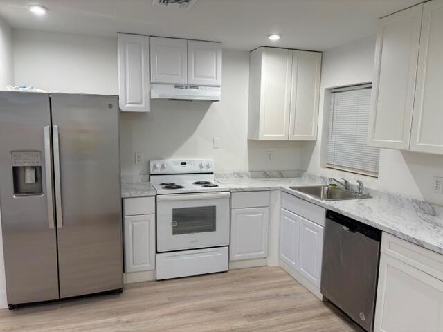 A kitchen with white cabinets, stainless steel appliances, and marble-patterned countertops — 2002 Avenue P, Fort Pierce FL 34950, FORT PIERCE, FL