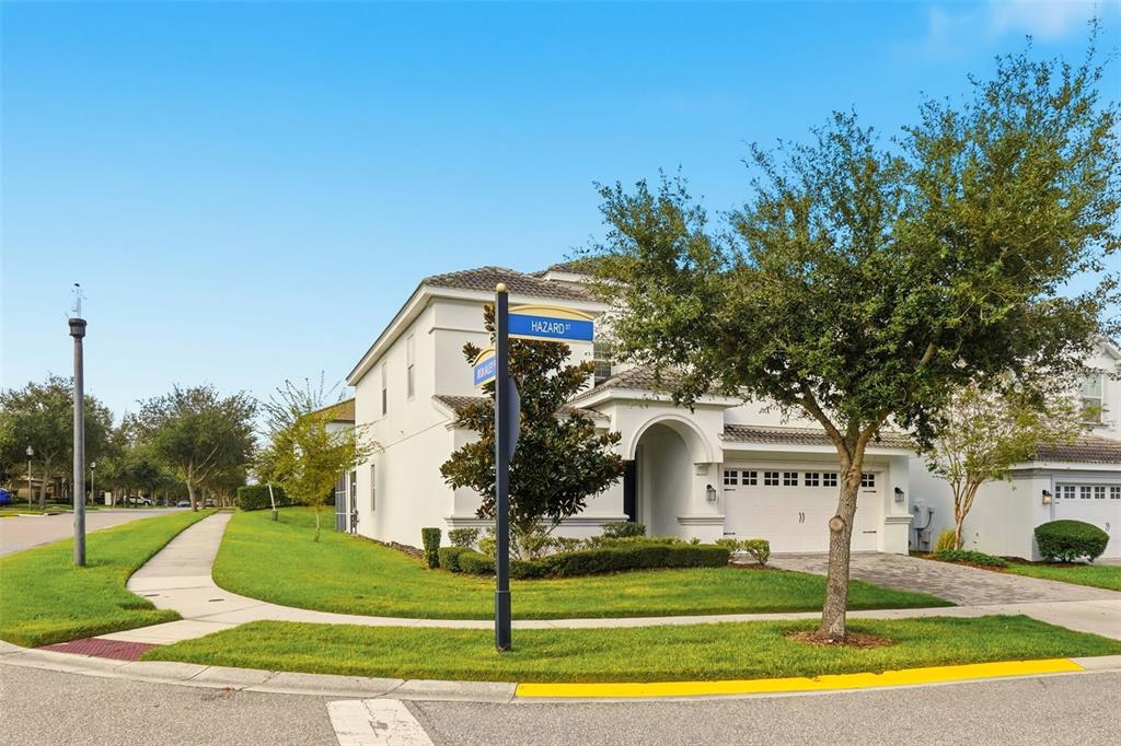A two-story white stucco house with a two-car garage sits on a corner lot — 9099 HAZARD STREET, DAVENPORT, FL