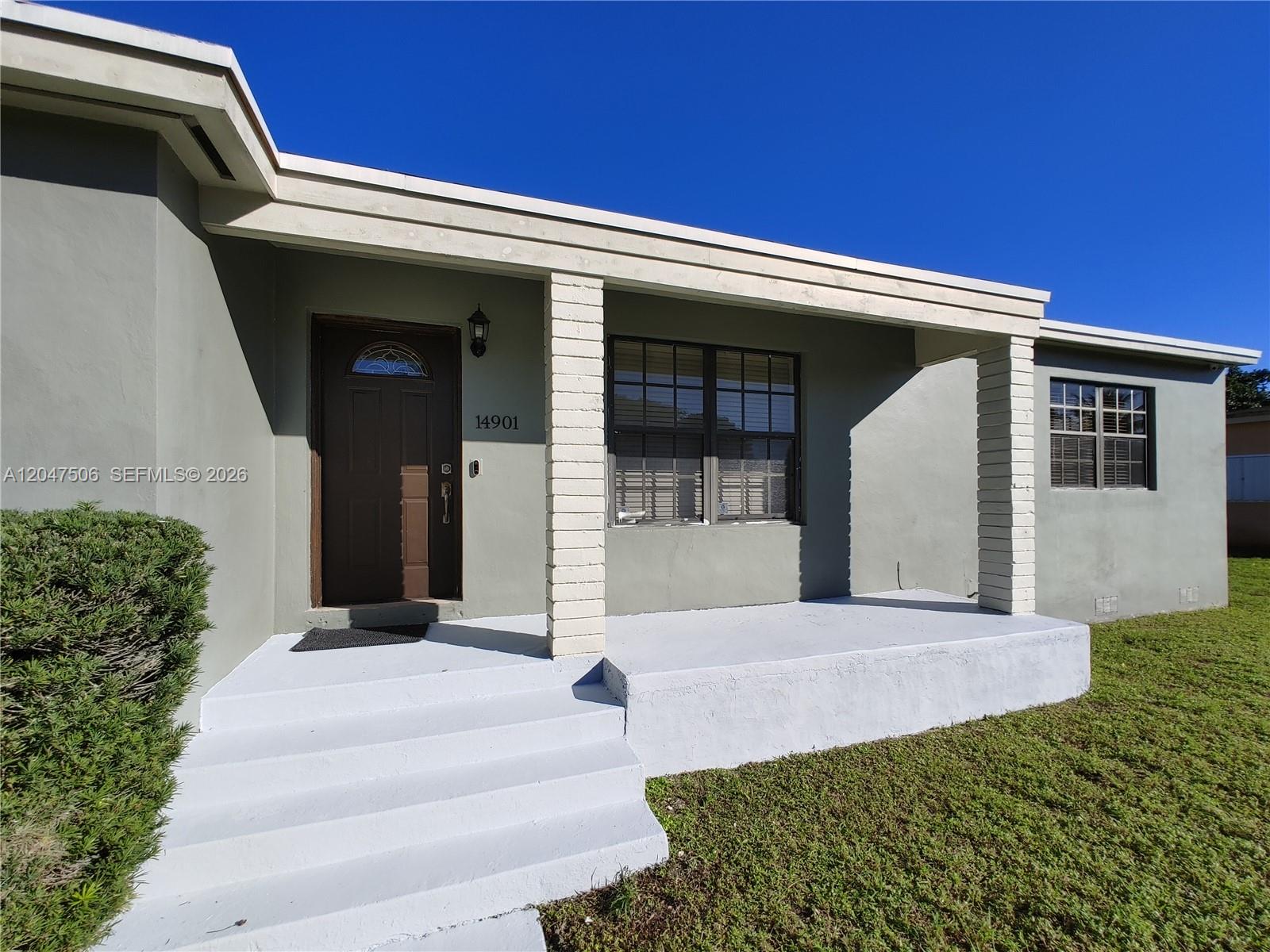A gray house features a covered front porch with white brick columns and stairs — 14901 NW 9th Ct # 14901, Miami FL 33168, MIAMI, FL