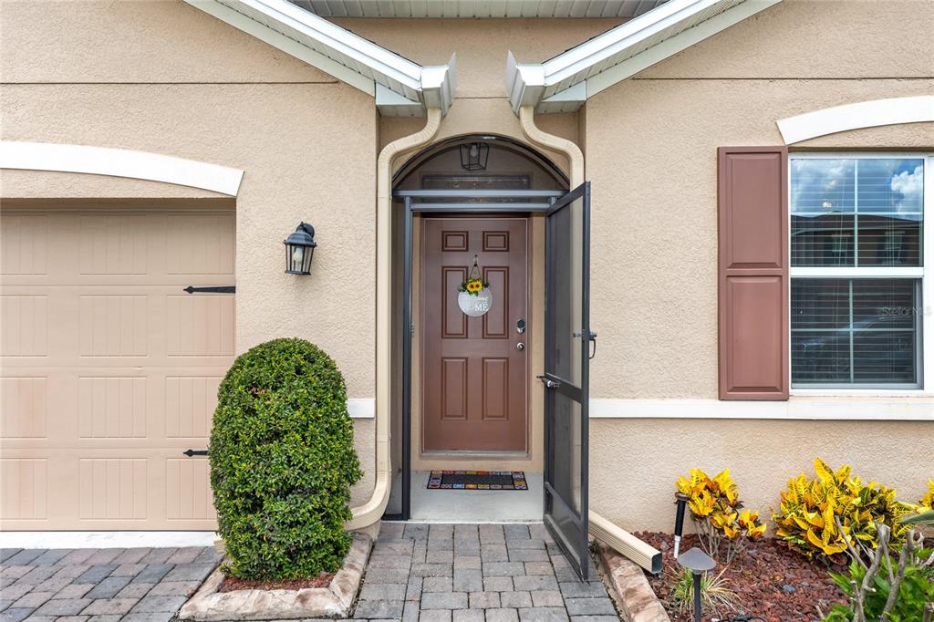 The exterior view shows a tan stucco house with a brown front door and garage — 839 LAZIO CIRCLE, DEBARY, FL