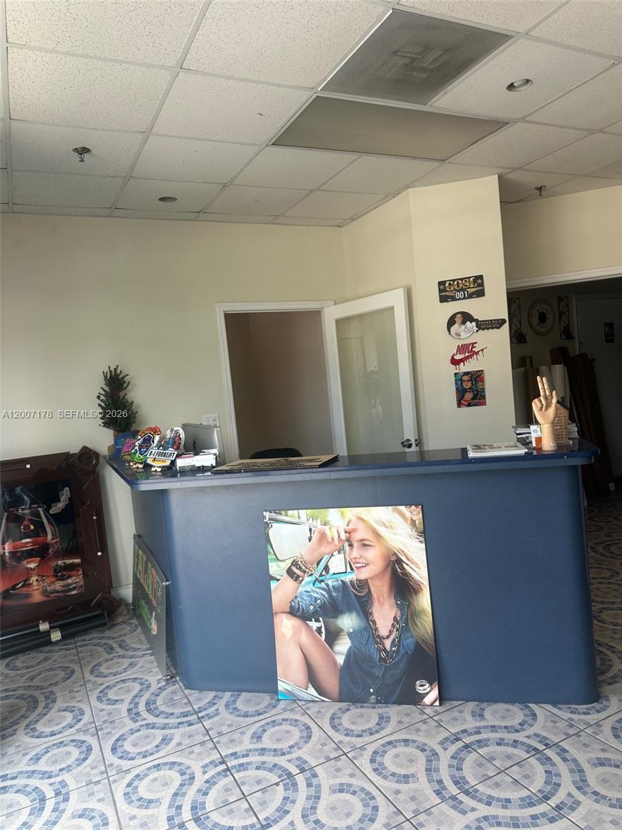 A reception desk with a large portrait sits in a room with tiled floors — 12101 NW 98th Ave, Hialeah Gardens FL 33018, HIALEAH GARDENS, FL