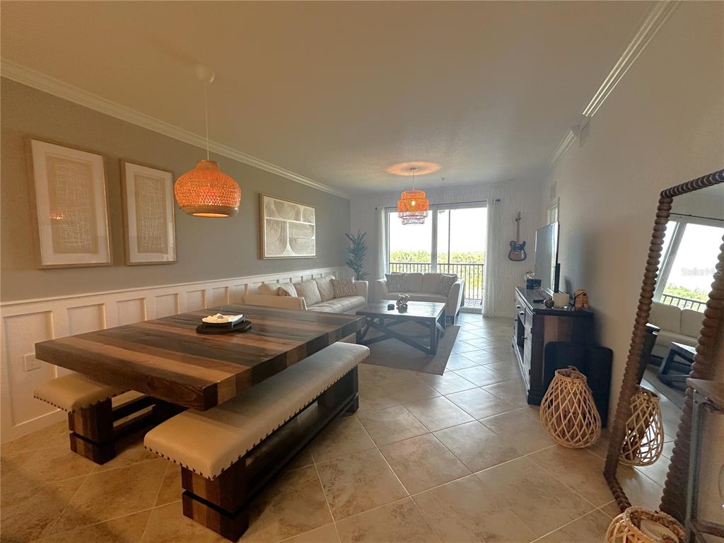 A living and dining room features a wooden table, neutral seating, and tile flooring — 14091 HERITAGE LANDING BOULEVARD UNIT 134, PUNTA GORDA, FL