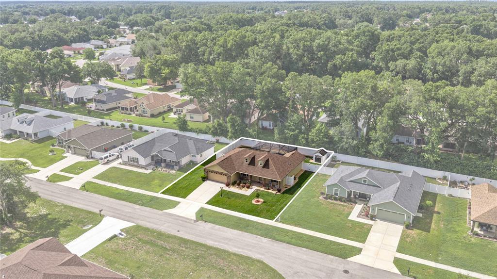 An aerial view shows a suburban house with a brown roof and a screened-in pool — 6658 SW 109TH LANE, OCALA, FL