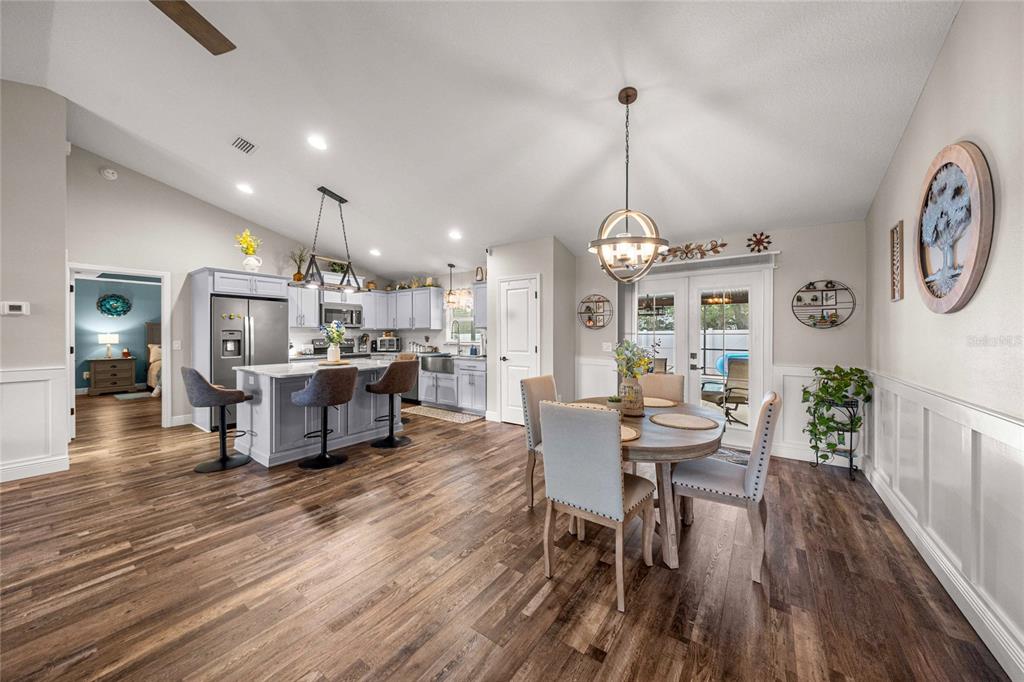 A kitchen and dining area with light blue cabinets, a central island, and wood flooring — 6658 SW 109TH LANE, OCALA, FL