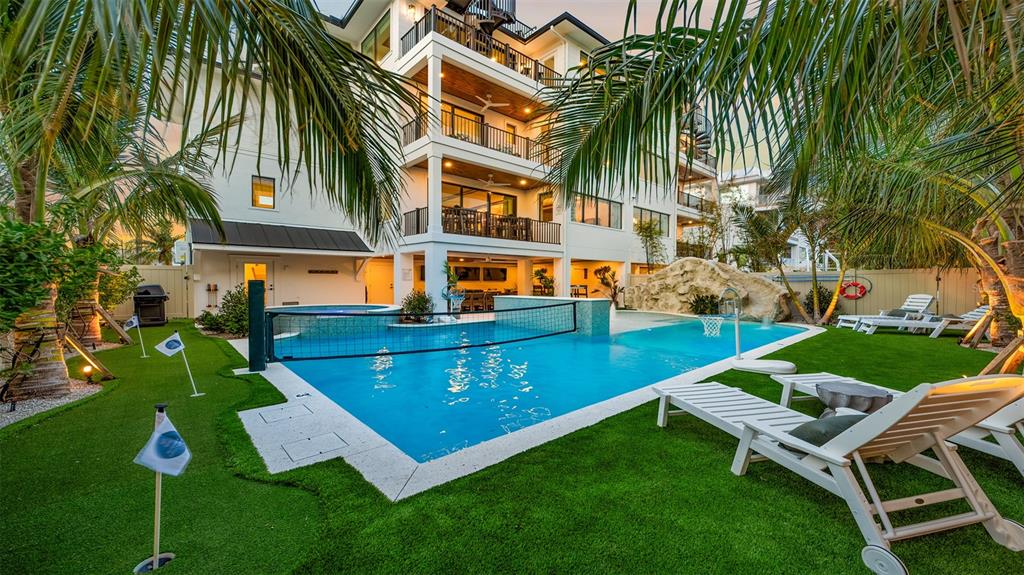 A multi-story house with a swimming pool, volleyball net, and putting green in the backyard — 1142 WINDSONG LANE UNIT B, SARASOTA, FL
