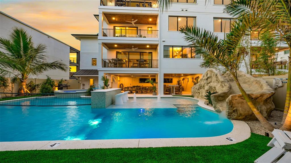 A multi-story house features a swimming pool with a rock slide and a swim-up bar — 1142 WINDSONG LANE UNIT B, SARASOTA, FL