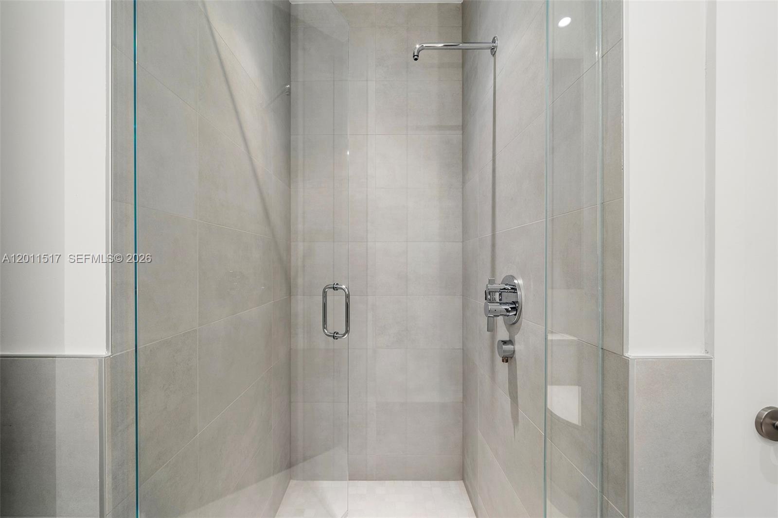 A walk-in shower features light gray tiled walls, a glass door, and chrome fixtures — 500 Alton Rd # 501, Miami Beach FL 33139, MIAMI BEACH, FL
