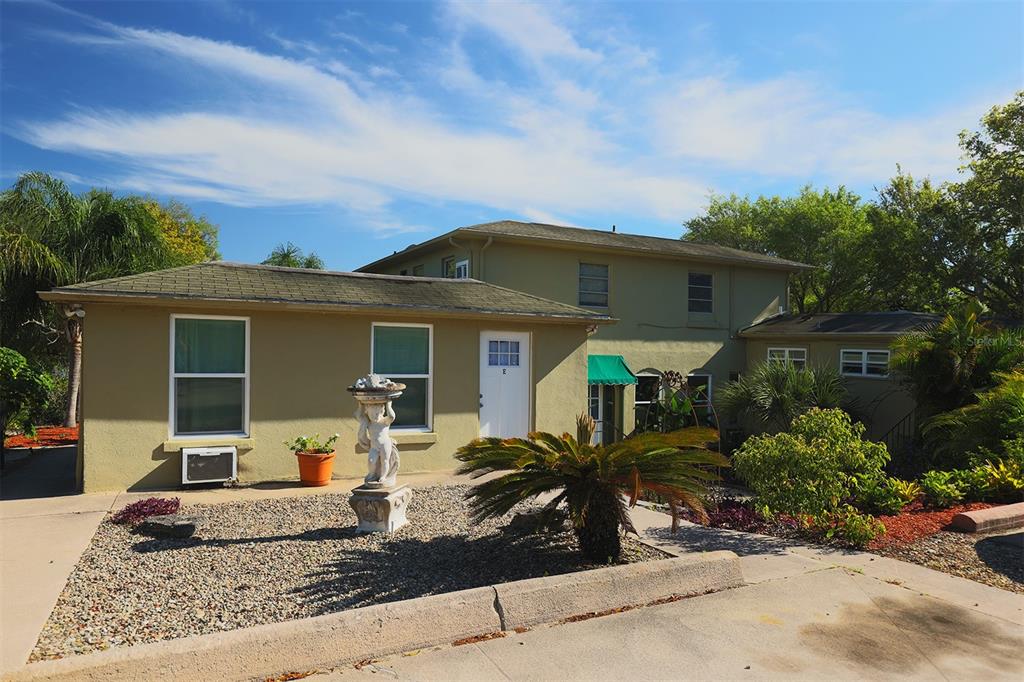 A two-story tan building with a gravel front yard and a decorative statue — 1854 HIGHLAND PARK DRIVE S UNIT A-F, LAKE WALES, FL