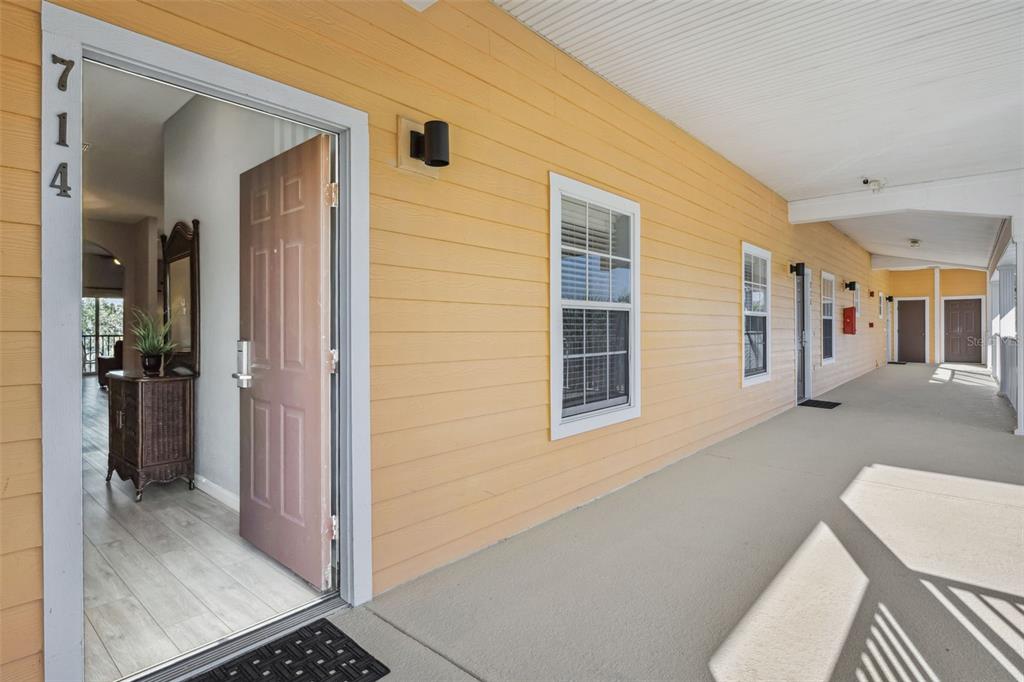 An open front door reveals a glimpse of an interior hallway with light-colored flooring — 714 NEW PROVIDENCE PROMENADE, DAVENPORT, FL