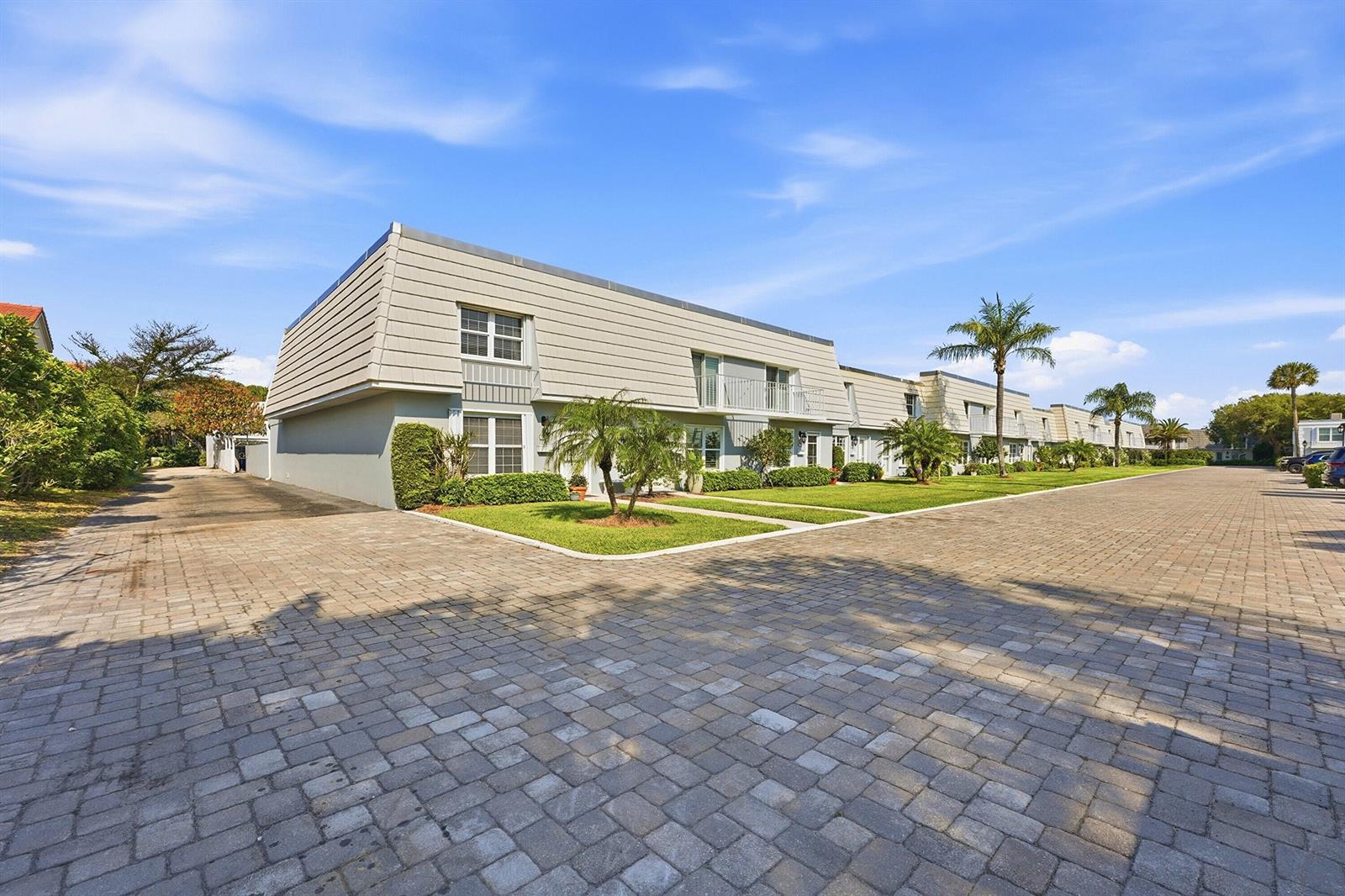 A multi-unit residential building with a paved driveway and palm trees under a blue sky — 2701 Ocean Drive # 1a, Vero Beach FL 32963, VERO BEACH, FL