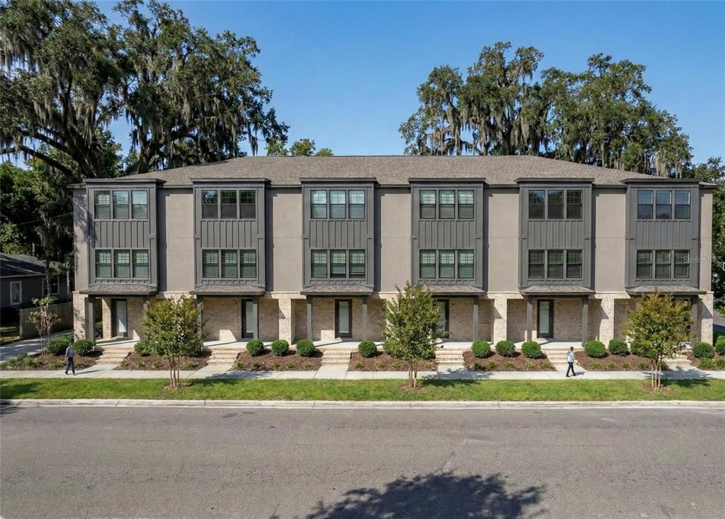 A multi-unit townhouse building with gray siding, brick accents, and large windows — 3208 N TAMPA STREET, TAMPA, FL