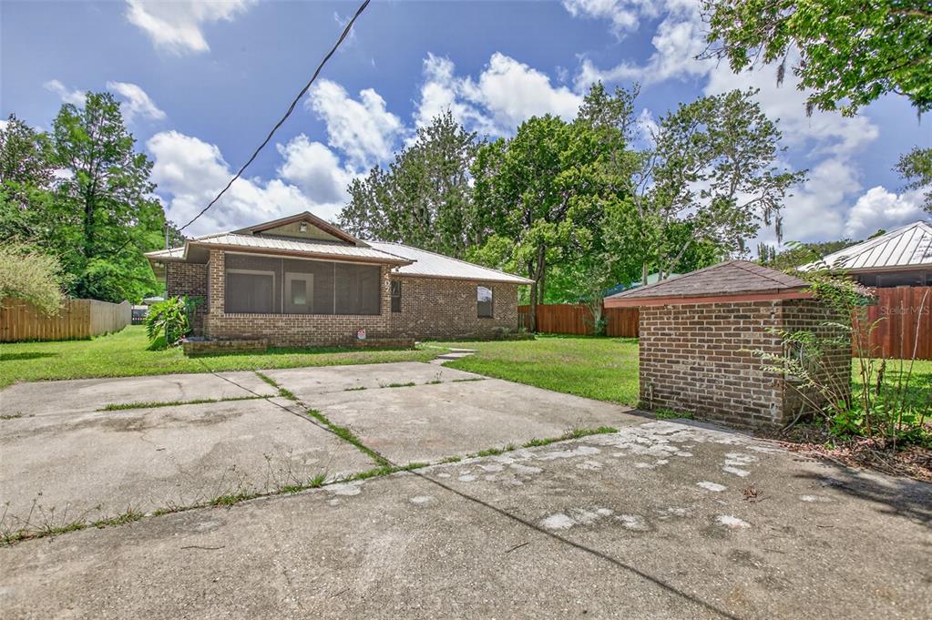 A brick house with a screened porch and a detached brick structure on a concrete lot — 407 POMONT AVENUE, ST AUGUSTINE, FL