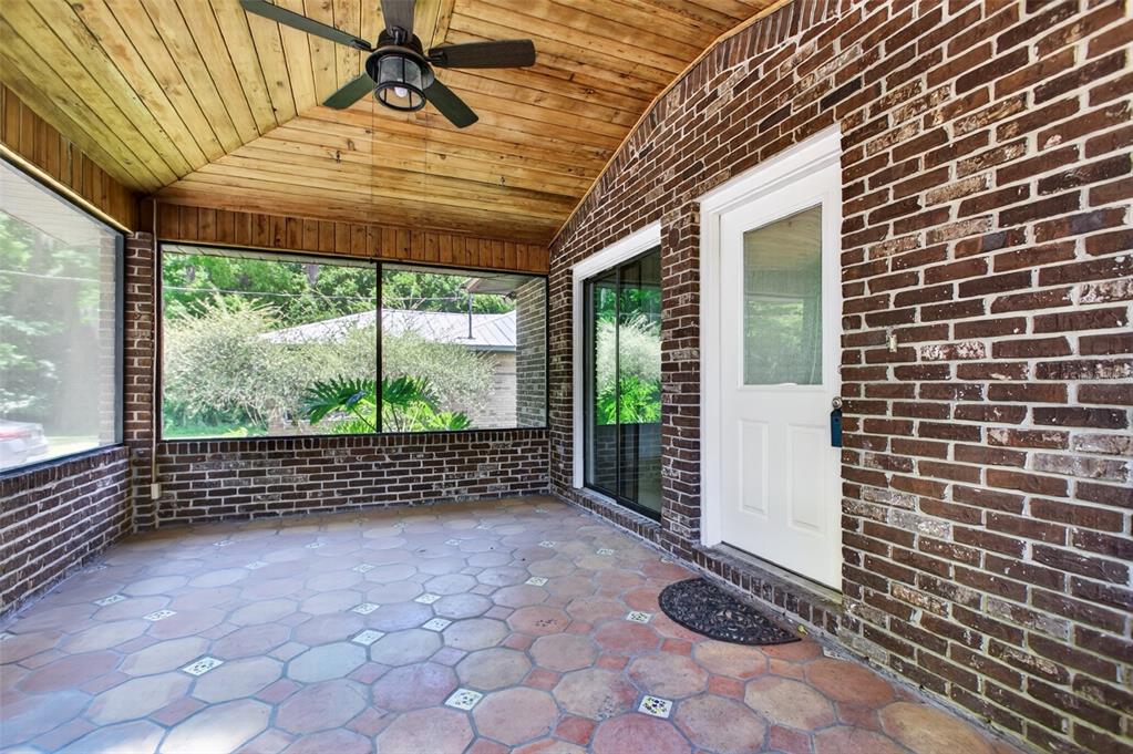 A screened-in porch features a wood-paneled ceiling, brick walls, and a hexagonal tile floor — 407 POMONT AVENUE, ST AUGUSTINE, FL