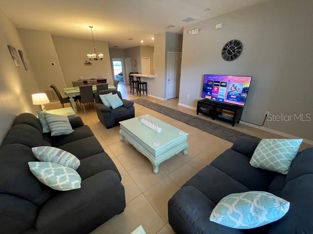 A living room features dark gray sofas, a light blue coffee table, and a television — 3143 SUN LAKE COURT UNIT B, KISSIMMEE, FL