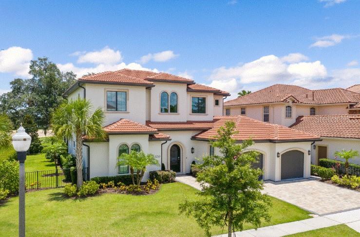 A two-story stucco house with a red tile roof and an attached garage — 1253 RADIANT STREET, REUNION, FL
