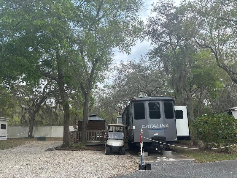 A Catalina travel trailer and a golf cart are parked on a gravel lot — 14403 252ND COURT ROAD NE UNIT 128, FORT MC COY, FL