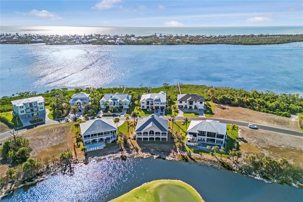 An aerial view shows waterfront homes situated along a canal and a golf course — 10030 EAGLE PRESERVE DRIVE, ENGLEWOOD, FL