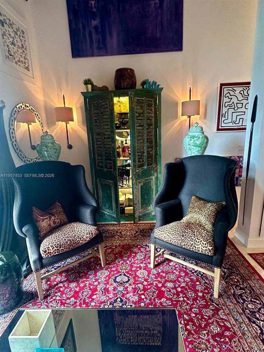 Two dark wingback chairs with leopard-print cushions sit on a red patterned rug before a cabinet — 1050 Brickell Ave # 818, Miami FL 33131, MIAMI, FL