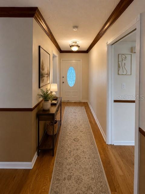 A hallway features hardwood floors, a long runner rug, and a door with a glass insert — 1029 W COUNTRY CLUB CIRCLE, PLANTATION, FL