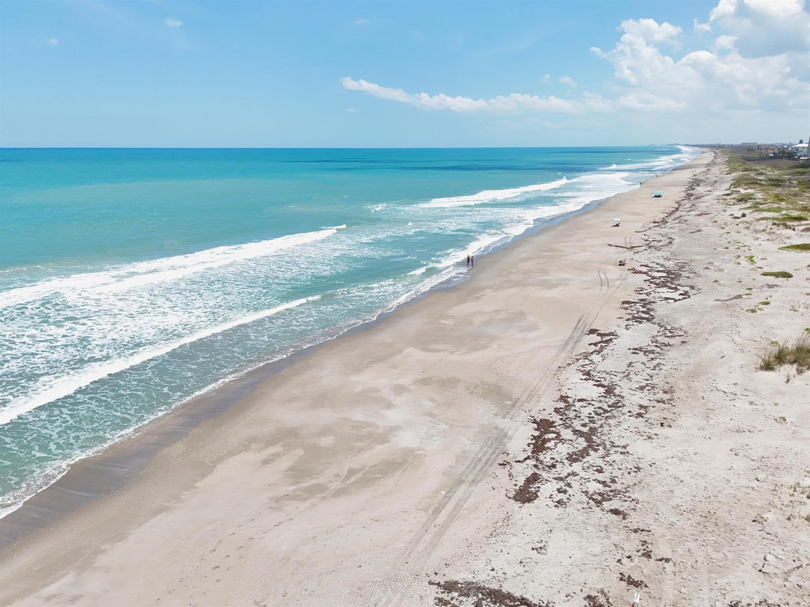 An aerial view of a sandy beach coastline with turquoise ocean waves and blue skies — 2465 S Atlantic Avenue # 401, Cocoa Beach FL 32931, COCOA BEACH, FL