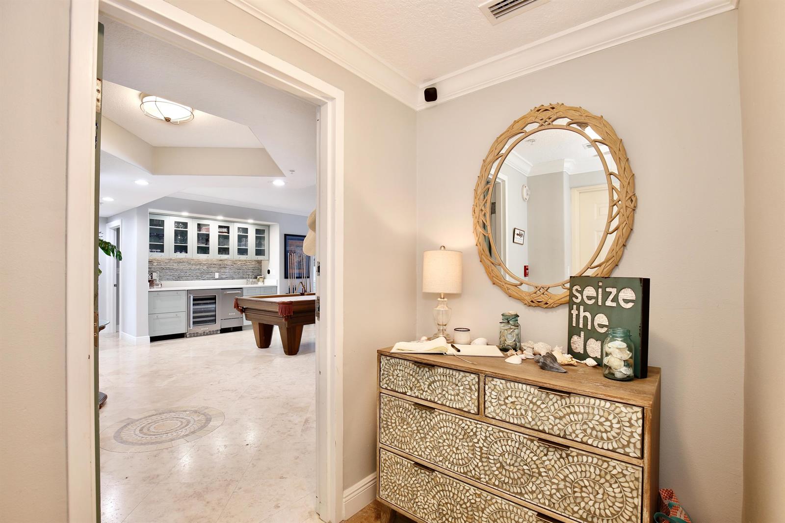 A foyer with a patterned dresser and mirror leads into a room with a pool table — 2465 S Atlantic Avenue # 401, Cocoa Beach FL 32931, COCOA BEACH, FL