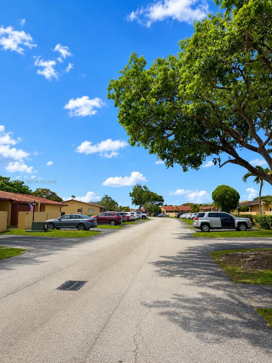 A paved street runs between rows of single-story residential buildings with parked cars — 14725 SW 86th Ln, Miami FL 33193, MIAMI, FL