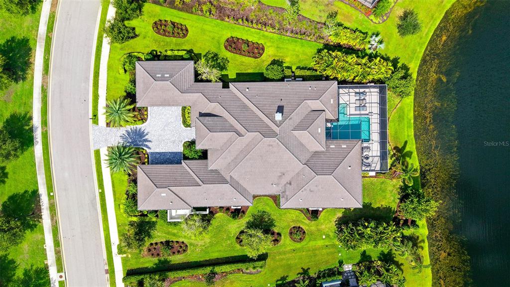 An aerial view shows a house with a tiled roof, pool enclosure, and landscaped yard — 8339 LUCERNE LOOP, BRADENTON, FL