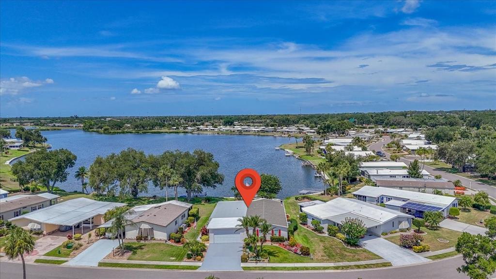 An aerial view of a suburban house with a red location pin near a lake — 8469 IMPERIAL LAKES CIRCLE, PALMETTO, FL