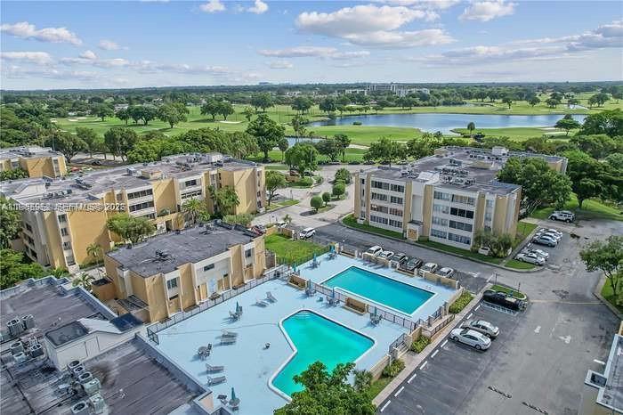 An aerial view shows apartment buildings surrounding a swimming pool with a golf course nearby — 6901 SW 147th Ave # 2E, Miami FL 33193, MIAMI, FL