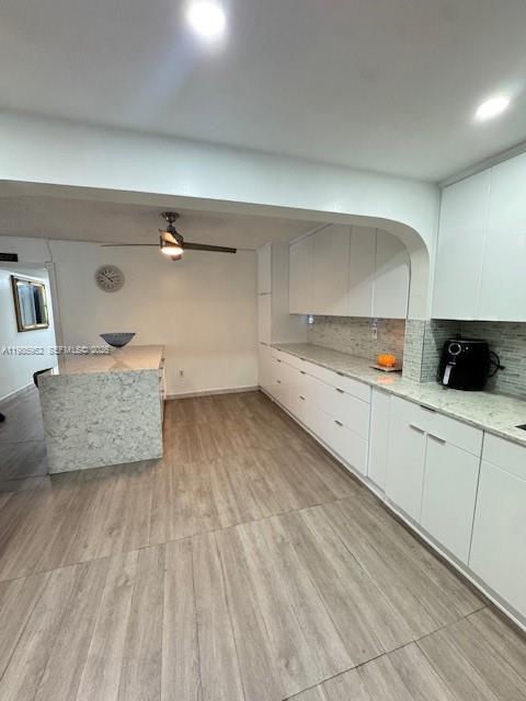 A kitchen features white cabinetry, a marble-patterned island, and light wood-look flooring — 6901 SW 147th Ave # 2E, Miami FL 33193, MIAMI, FL