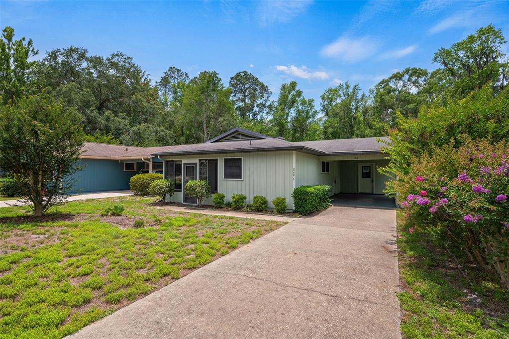 A single-story house with light green siding, a concrete driveway, and a covered entryway — 8496 NW 37TH TERRACE, GAINESVILLE, FL