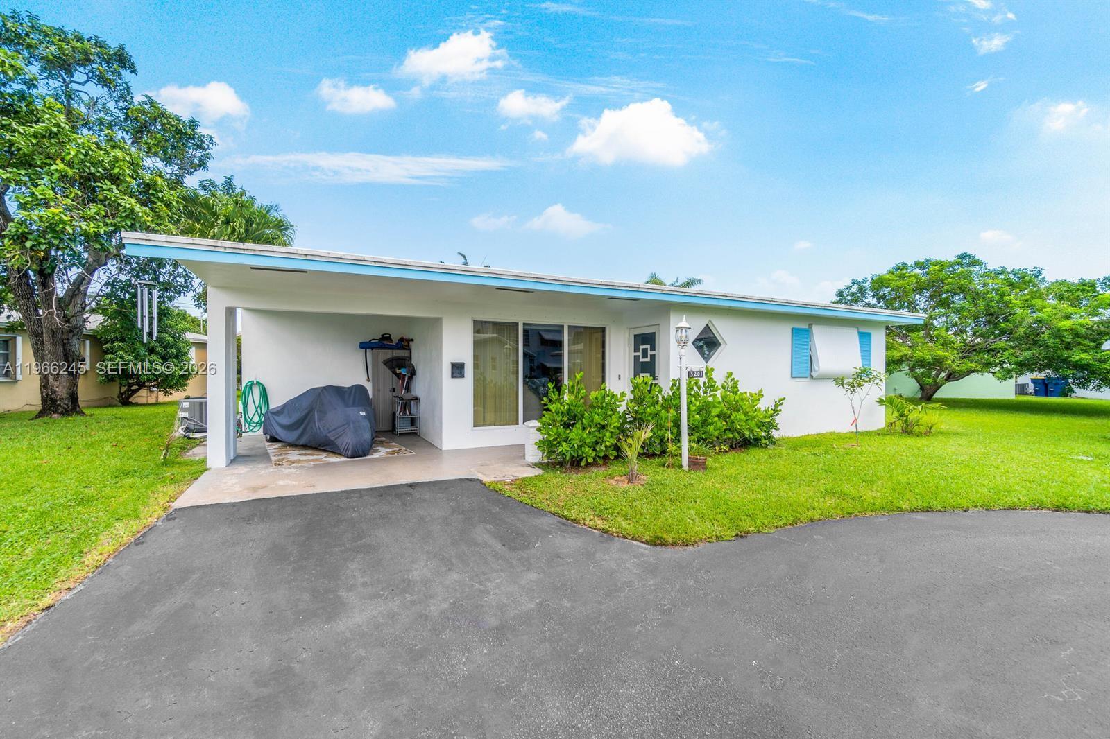 A white single-story house features a carport, a paved driveway, and a grassy front yard — 3201 Abbott Ln, Hollywood FL 33021, HOLLYWOOD, FL