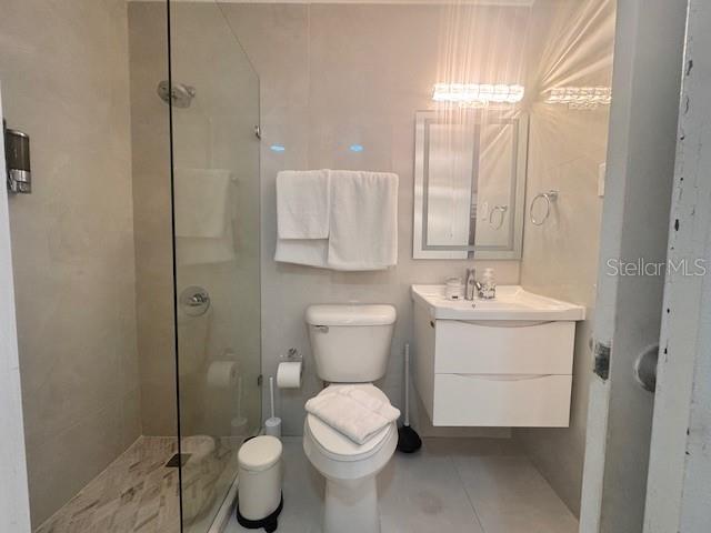 A modern bathroom features a glass-enclosed shower, a white vanity, and a wall-mounted toilet — Ocean Drive 100 UNIT 806, LUQUILLO, PR